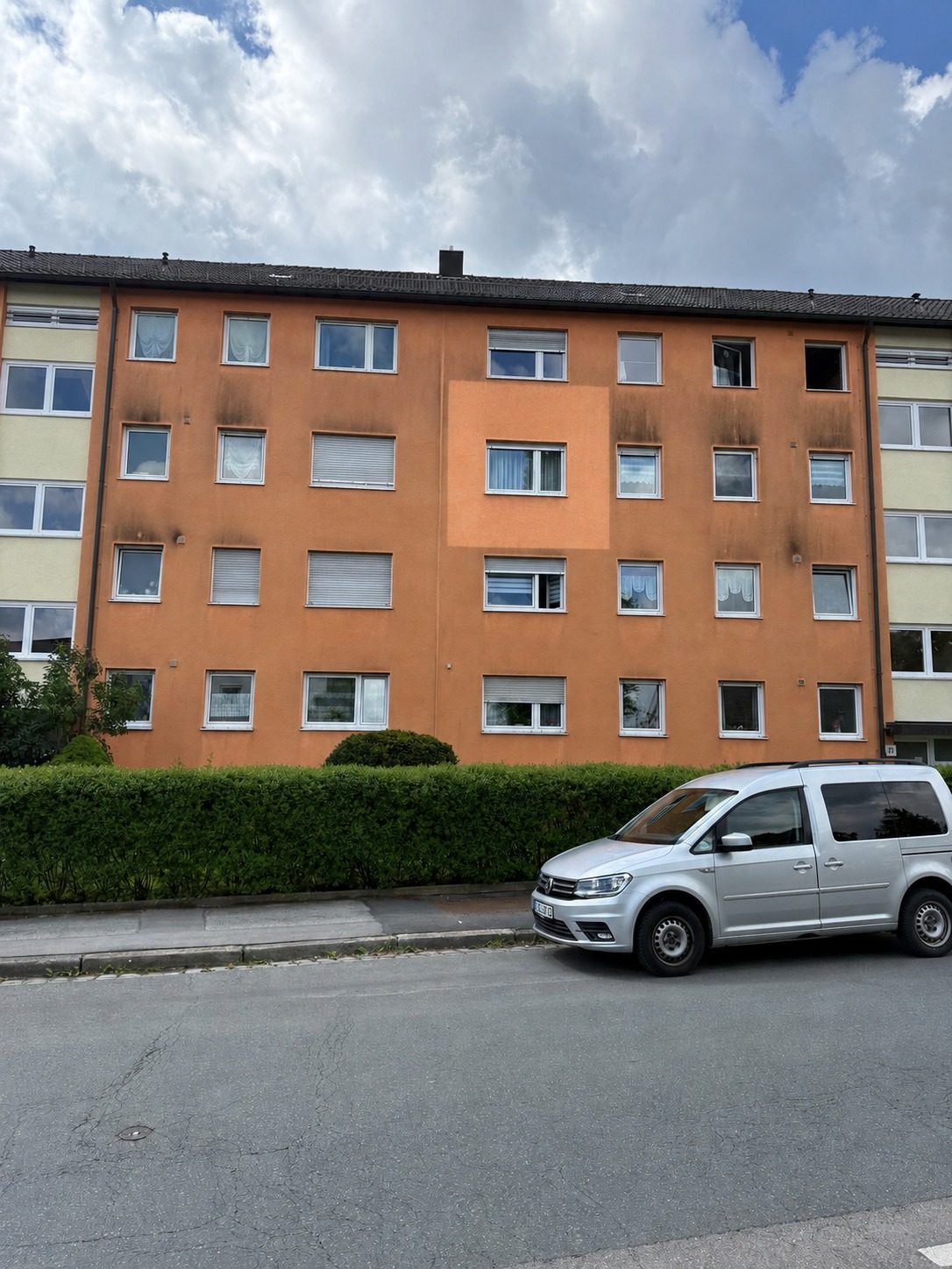 Mehrfamilienhaus mit frisch gereinigter Probefläche – der helle Bereich hebt sich deutlich von der verschmutzten Fassade ab